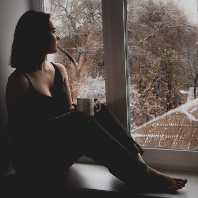 戴眼镜的中年男性在书房里对着比赛录像做笔记，桌上摊开着数据表格，暖色台灯下的专注工作场景