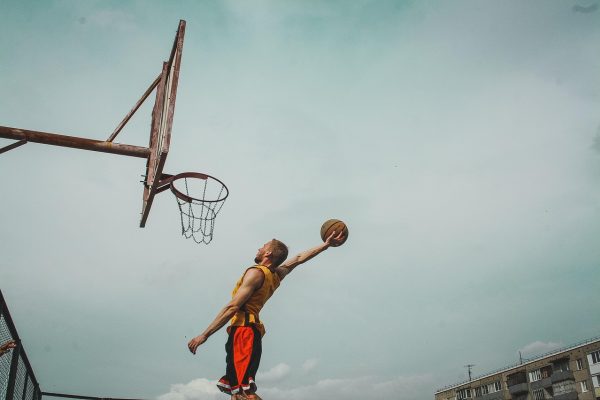 nba虎扑 篮球馆木质地板上球员急停跳投的瞬间，观众席灯光昏黄，运动感强烈
